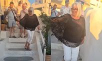 Toeristen strooien as uit op drukke trap in Santorini