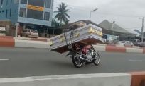 Nigeriaanse waaghals stunt met doodskist achterop motor gaat compleet viraal