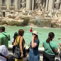 Tokkietoerist neemt een frisse duik in de Trevi fontein