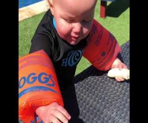 Hilarisch filmpje van baby die probeert een banaan te eten met zwembandjes aan